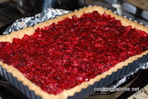 Торт с коржами из безе и песочного теста и клюквенным вареньем.