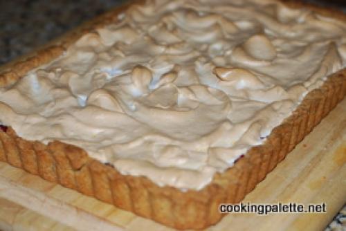 Торт с коржами из безе и песочного теста и клюквенным вареньем.