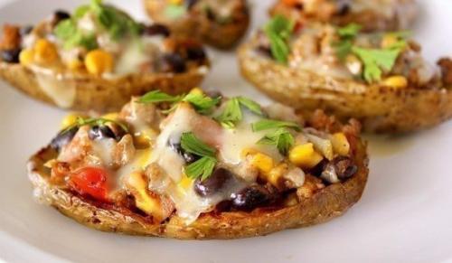 Запеченные половинки картофеля с фаршем, сыром и приправами.