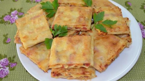 Закуска из лаваша с колбасой, помидорами и чесноком.