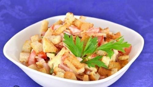 Салат из помидоров с грудинкой, сыром и сухариками.